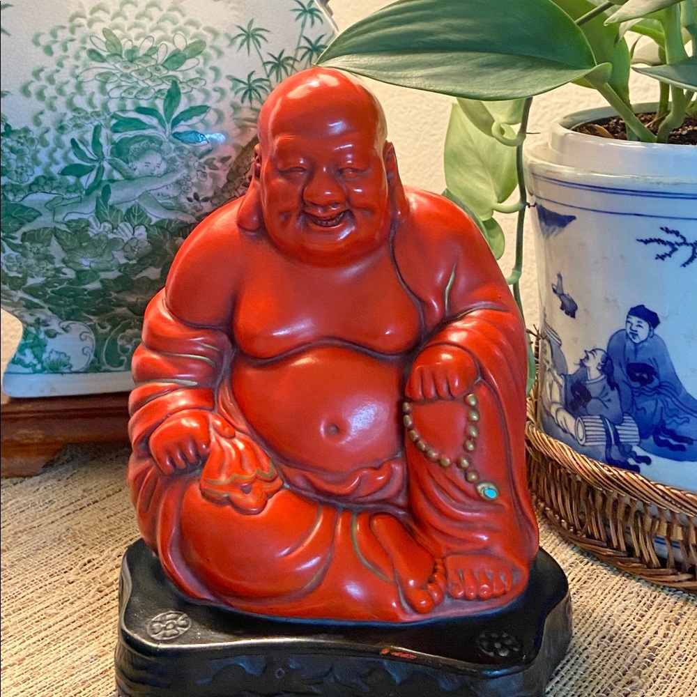 Vintage red smiling Buddha statue